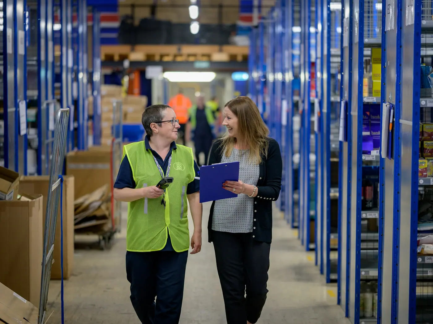 Duas pessoas conferindo produtos dentro de um centro de distribuição